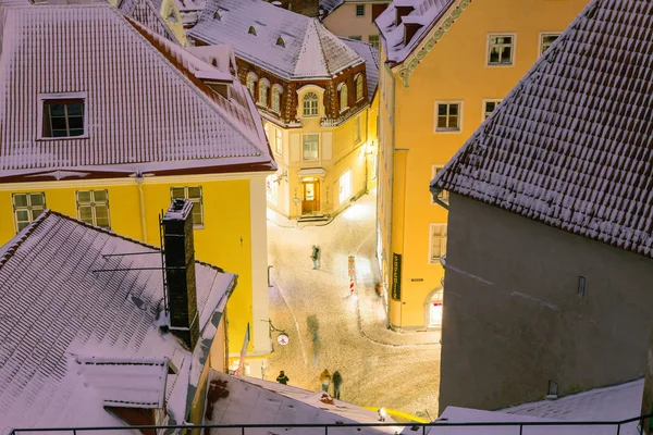 TALLINN, ESTONIA - 07 GENNAIO 2017: Strade innevate e tetti del centro storico. Vita notturna invernale . — Foto Stock