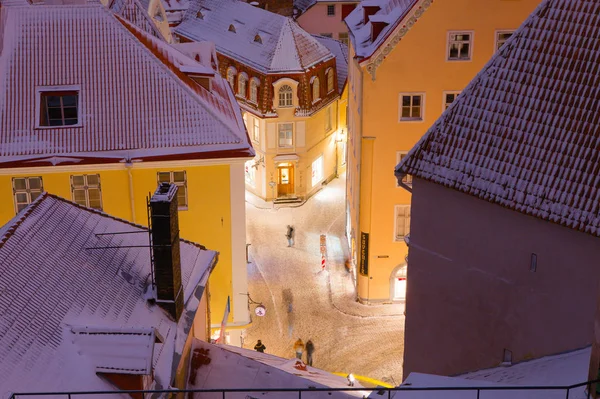 TALLINN, ESTONIA - 07 GENNAIO 2017: Strade innevate e tetti del centro storico. Vita notturna invernale . — Foto Stock