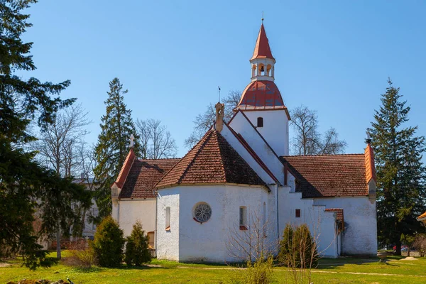 Traditional local Estonian Lutheran church. White stone and red tile roof.