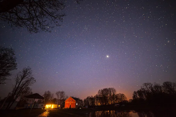 Plano nocturno de cabañas de madera y cielo estrellado . — Foto de Stock