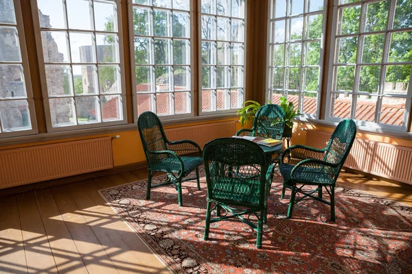 Jasny pokój w domku z wiklina rattan krzesła i stół. Duże okna i światło słoneczne. — Zdjęcie stockowe