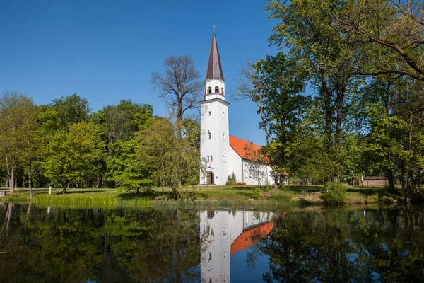 Evangélikus templom a Szent Berthold tükörképe a tóban. Sigulda, Lettország. — Stock Fotó