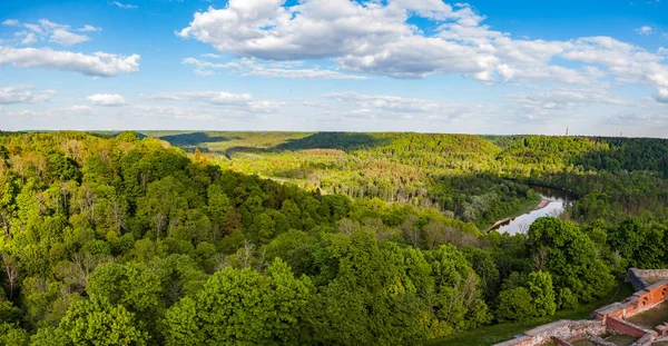Güzel gökyüzü ve bulutlar yeşil orman, Güneş tarafından kaplı tepeler üzerinde. Turaida Kalesi: Gauja Nehri, Letonya yakınında vurdu.