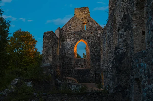 Veduta notturna delle mistiche rovine illuminate dell'antico castello Livoniano nel centro storico di Sigulda, Lettonia — Foto Stock