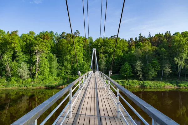 Ponte de caminho de madeira por cabo sobre o rio Gauja com floresta ao fundo — Fotografia de Stock