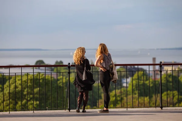 Tallinn, Estonya - 02 Haziran 2016. İki genç kadın gözlem güverteden şehir manzarasının tadını çıkarın. Güneşli yaz gün.