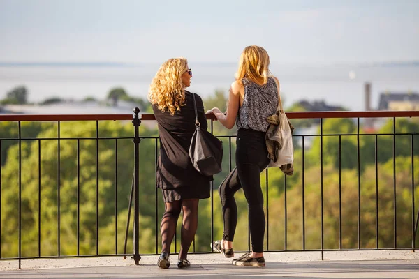 Tallinn, Estonya - 02 Haziran 2016. İki genç kadın gözlem güverteden şehir manzarasının tadını çıkarın. Güneşli yaz gün.