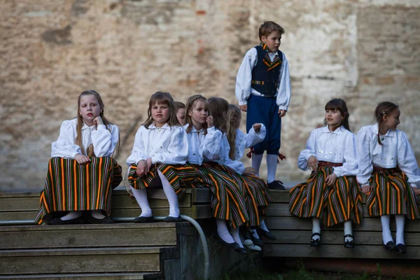 TALLINN, ESTONIA - 02 JUN 2016: Estiske folkedansere med traditionelle farverige mønsterdragter. Folklore festival i gamle bypark . - Stock-foto