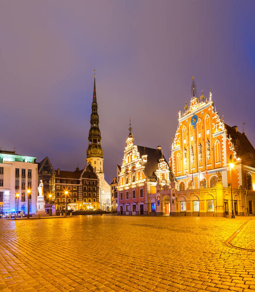RIGA, LATVIA - 20 JUN 2016: City Hall Square with House of the Blackheads and Saint Peter church in Riga Old Town at night.
