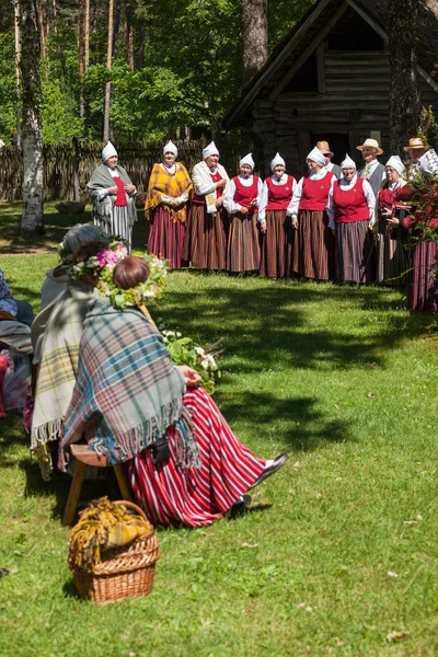 RIGA, Letonia - 12 JUN 2016: Los letones cantan canciones folclóricas con trajes nacionales. Museo Etnográfico Letón . —  Fotos de Stock