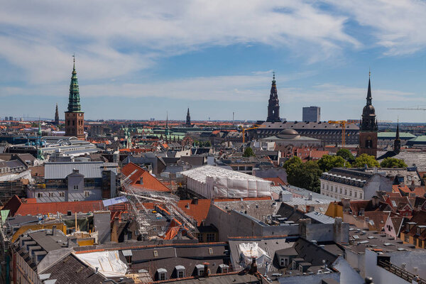 Cityscape of Copenhagen from the Round Tower. Old churches towers and roof reconstruction of city center.