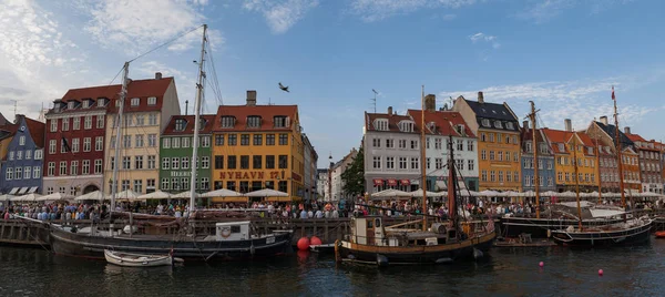 COPENAGEN, DANIMARCA - 26 GIUGNO 2016: Le persone si rilassano nel piccolo canale con case colorate e barche. Vista panoramica . — Foto Stock