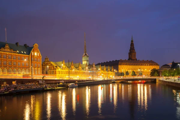 Ночной вид на Кристиансборгский дворец и здание фондовой биржи через канал в Копенгагене . — стоковое фото