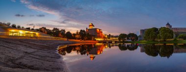 Narva Nehri üzerinde Ortaçağ kale yansıma gün batımında, görünümle şaşırtıcı Estonya ve Rusya sınır. Geniş panoramik çekim