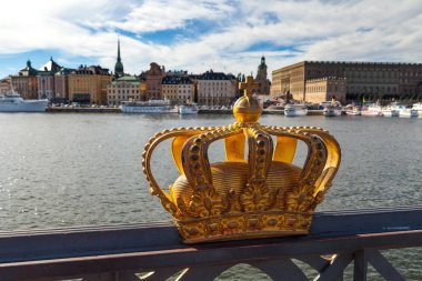Altın taç Stockholms yuvası (Kraliyet Sarayı) içinde belgili tanımlık geçmiş bulunan Skeppsholm Köprüsü'nde. Stockholm, İsveç