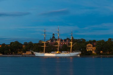 Stockholm gece vew. Şehir set boyunca ışıklı tekneler.
