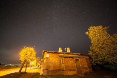 Küçük kasaba ile eski ahşap evler sokak üzerinde yıldızlı gökyüzü. Sonbahar,