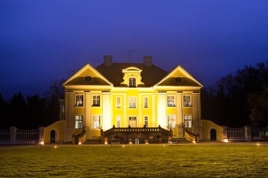 Gece Palmse manor, Estonya görünümünü aydınlatılmış. Lüks villa, park ve bilgi merkezi.