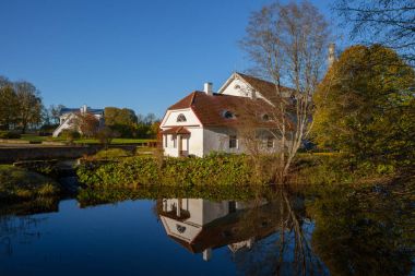 Gölet, sudaki yansıması ile eski taş damıtım güneşli bir gün.