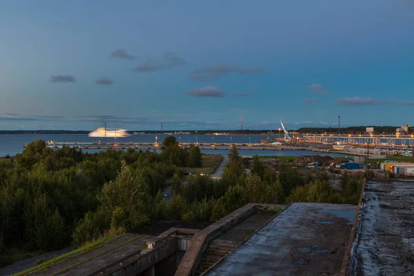TALLINN, ESTÔNIA - AGOSTO, 15, 2016: Panorama noturno do terminal de balsas. Vista da sala de concertos olímpica abandonada — Fotografia de Stock