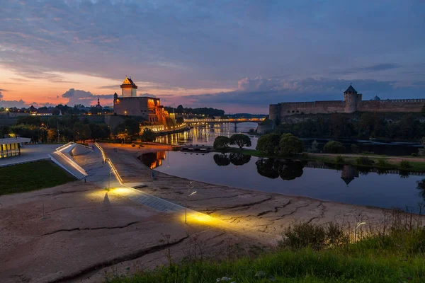 Golden sunset over two medieval fortresses on the river Narva, Estonia and Russia border. — Stock Photo, Image
