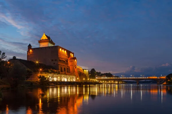 Illuminated medieval fortress on the river Narva, Estonia and Russia border. Blue hour — Stock Photo, Image
