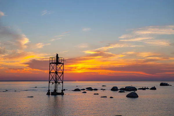 Solnedgång över havet med magiska installation av svart munk på tornet — Stockfoto