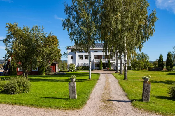 Casa de fazenda e estrada para ele. Casa de madeira branca com árvores. Hedemora, Suécia — Fotografia de Stock
