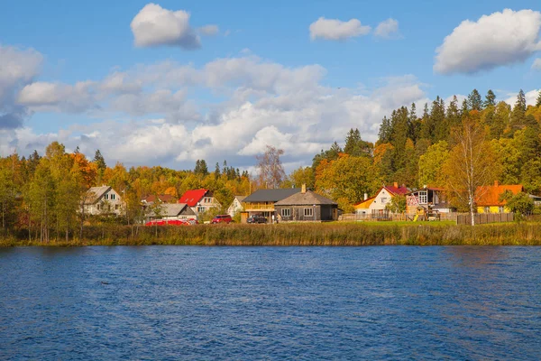 Rural scene behind the lake. Latvian village. Autumn moment.