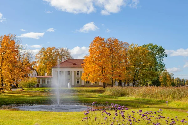 Parque de otoño con flores y fuente en el prado cerca de la antigua mansión. Tiempo de otoño brillante . —  Fotos de Stock