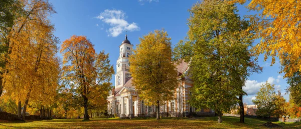 Őszi park régi templom. Aluksne, Lettország. — Stock Fotó