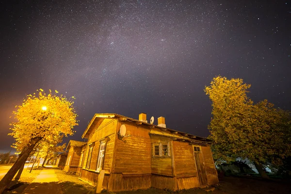 Cielo estrellado sobre la pequeña calle de la ciudad con viejas casas de madera. Tiempo de otoño , — Foto de Stock