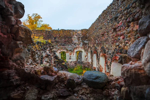 Reruntuhan kastil batu granit abad pertengahan pada waktu musim gugur. Dedaunan musim gugur. Rauna, Latvia — Stok Foto