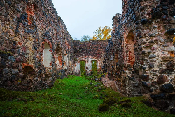 Ortaçağ taş granit Kalesi Sonbahar zaman yok eder. Sonbahar yaprakları. Rauna, Letonya
