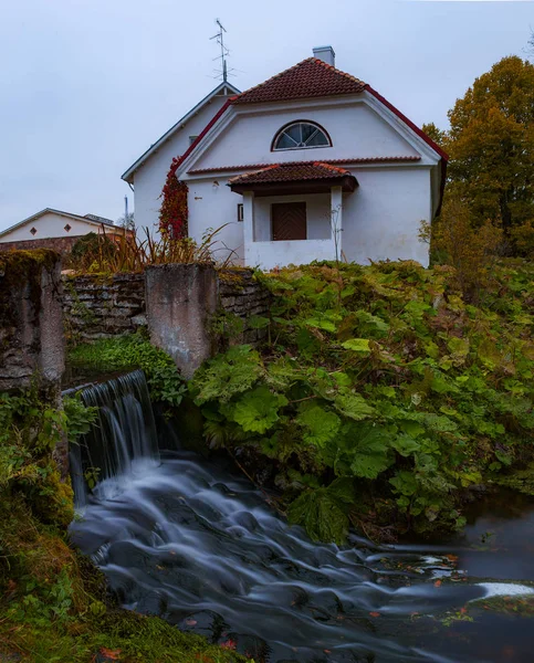 Creek between stones near building of old distillery. Night shot with long exposure. — Stock Photo, Image