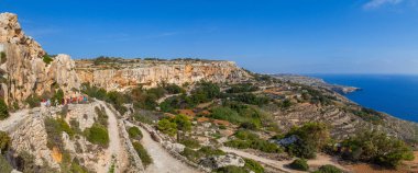 MALTA - 16 Ekim 2016: Malta adasının güney kıyısındaki kireçtaşı uçurumunda yürüyüş yapan bir grup. Yaz güneşli bir gün. Panoramik deniz manzarası.