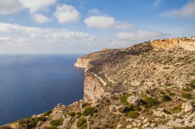 Malta adasının güney kıyısındaki kireçtaşı uçurumunda. Yaz güneşli bir gün. Panoramik deniz manzarası.
