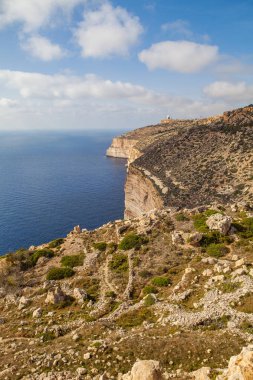 Malta adasının güney kıyısındaki kireçtaşı uçurumunda. Yaz güneşli bir gün. Panoramik deniz manzarası.