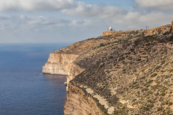 Malta adasının güney kıyısındaki kireçtaşı uçurumunda. Yaz güneşli bir gün. Panoramik deniz manzarası.