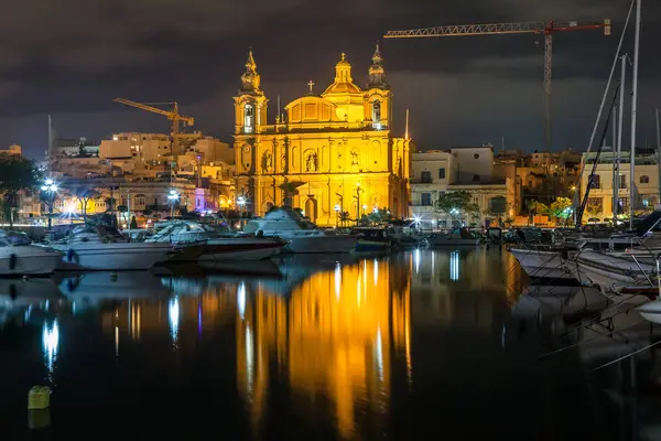 Güzel Msida Parish Kilisesi derin gece ile ön Harbor'da. Malta