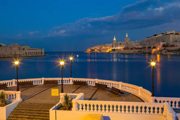 Verão incrível vista noturna de perfil Valetta sobre o mar com terraço em primeiro plano. Longa exposição. Arquitetura iluminada . — Fotografia de Stock