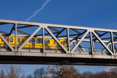 BERLİN, Almanya - 22 Şubat 2017: Sarı u-bahn treni metal köprüyü geçiyor