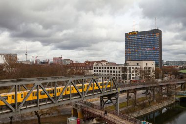 BERLIN, GERMANY - FEBRUARY 22, 2017: Yellow u-bahn train crossing the metal bridge clipart