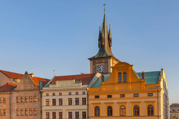 Iconic view of clock tower of roofs close to Charles bridge. Sunset time. Prague, Czech Republic.