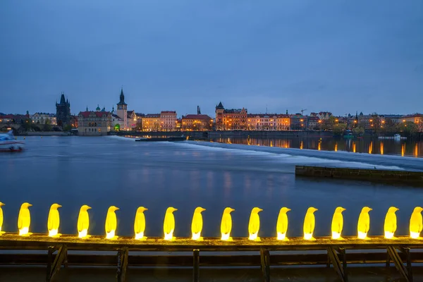 PRAGUE, CZECH REPUBLIC - APRIL 08, 2017: Night view of modern art installation of yellow penguins near Kampa museum island — Stock Photo, Image