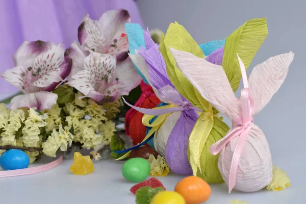 Flores, coelhos de Páscoa e doces em um fundo branco isolado — Fotografia de Stock