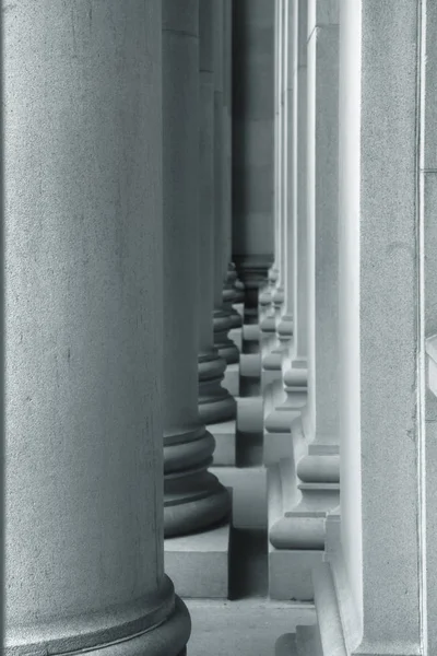 Narrow passage between tall pillars and wall — Stock Photo, Image