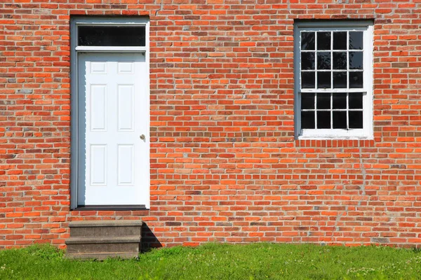 Puerta y una sola ventana en la pared de ladrillo — Foto de Stock