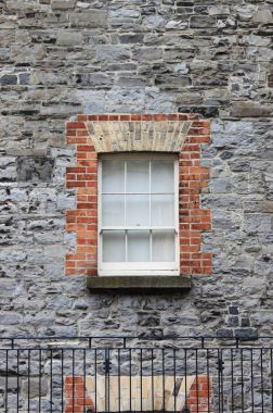 Kare penceresi üzerinde gri bir tuğla bina