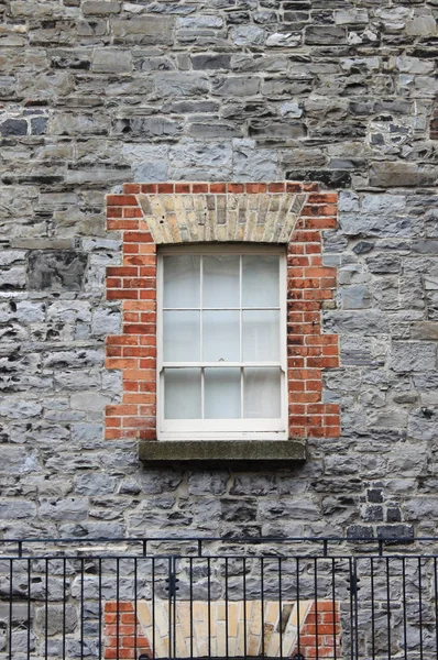 Janela quadrada em um prédio de tijolos cinza — Fotografia de Stock